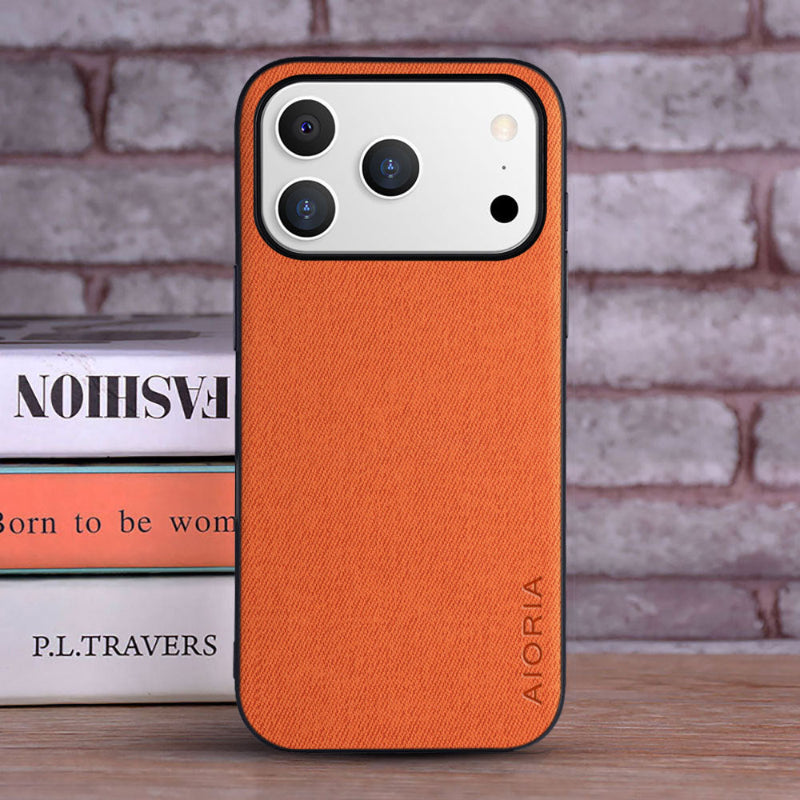 Orange phone case with 'ALORIA' branding on a brick wall background