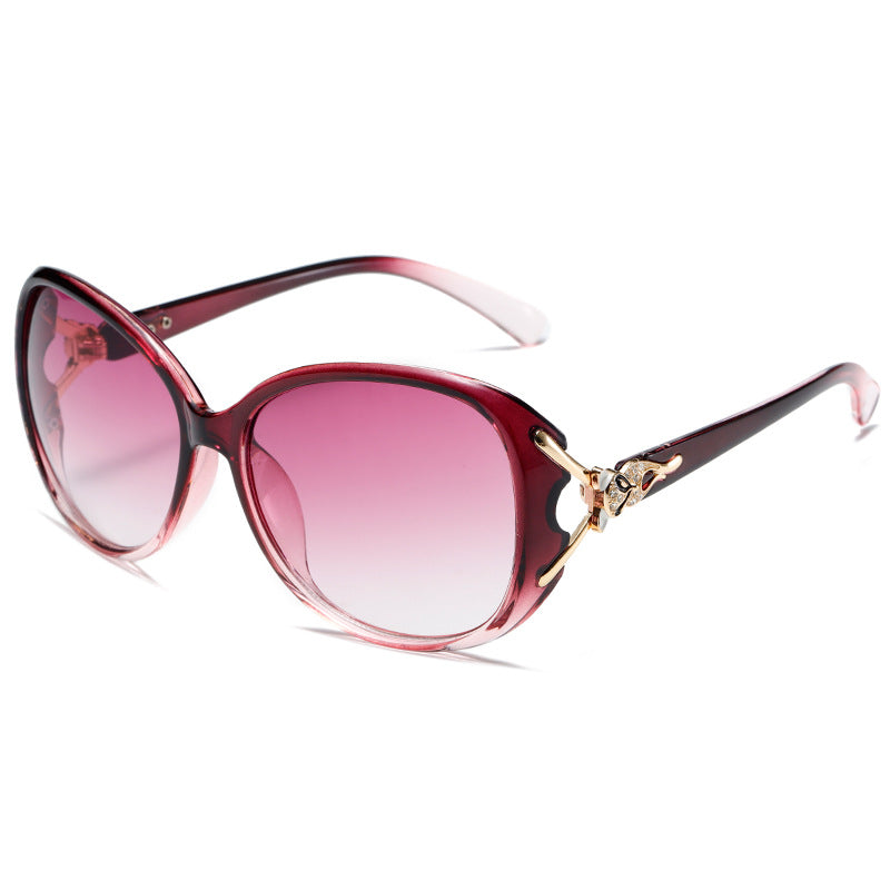 Sunglasses with pink gradient lenses and a decorative gold bow on a white background