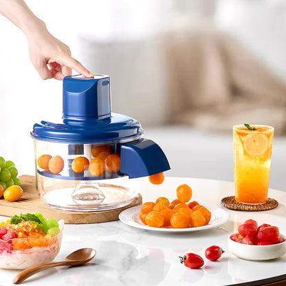 Fruit juicer with oranges, a glass of juice, and fruits on a table.