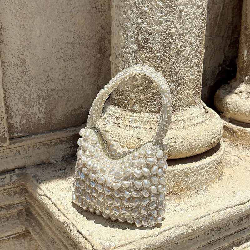White pearl-beaded mini handbag with top handle, woven bead pattern and scalloped edges