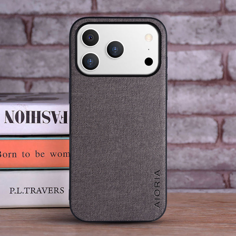 Gray phone case with 'ALORIA' branding on a brick wall background