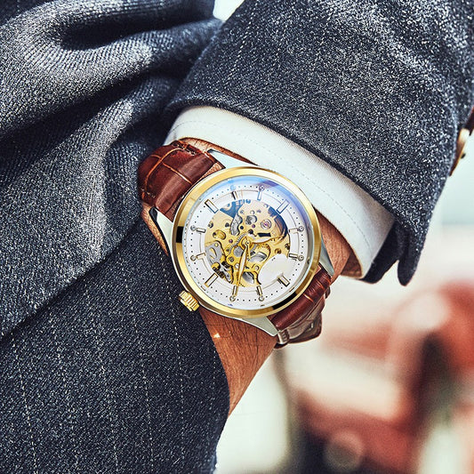 Gold-tone mechanical watch with brown leather strap, skeleton dial and blue hands