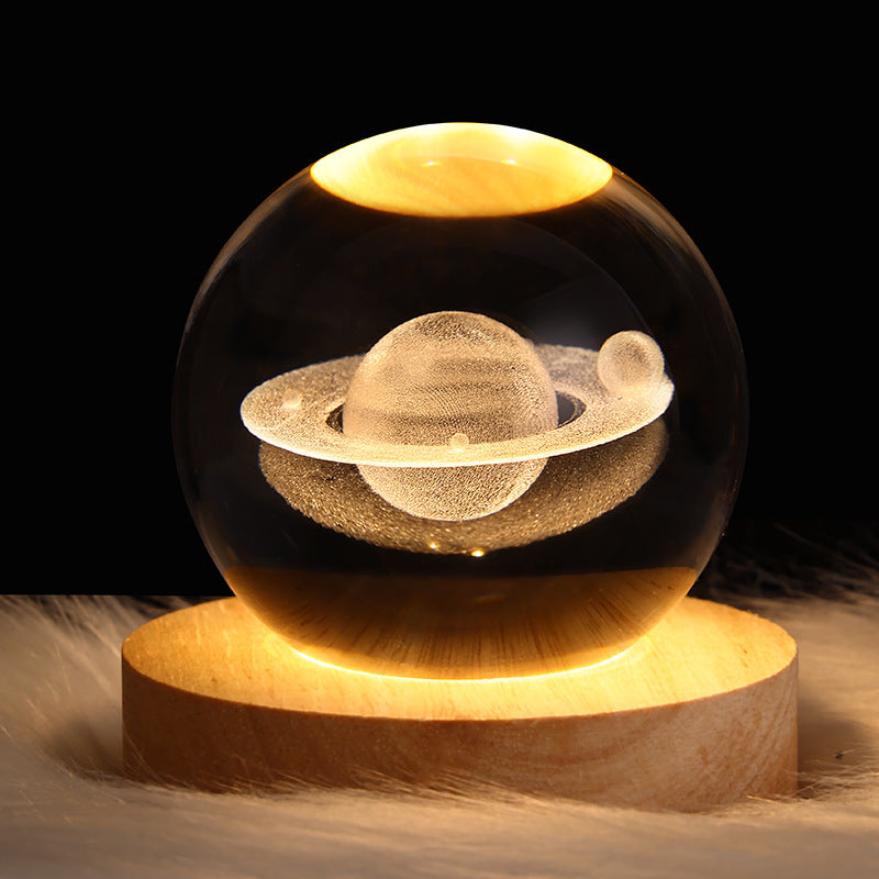 LED crystal ball night lamp with round wooden base and illuminated planet ring scene