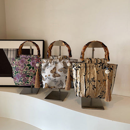 Three handbags with different designs on stands against a plain background