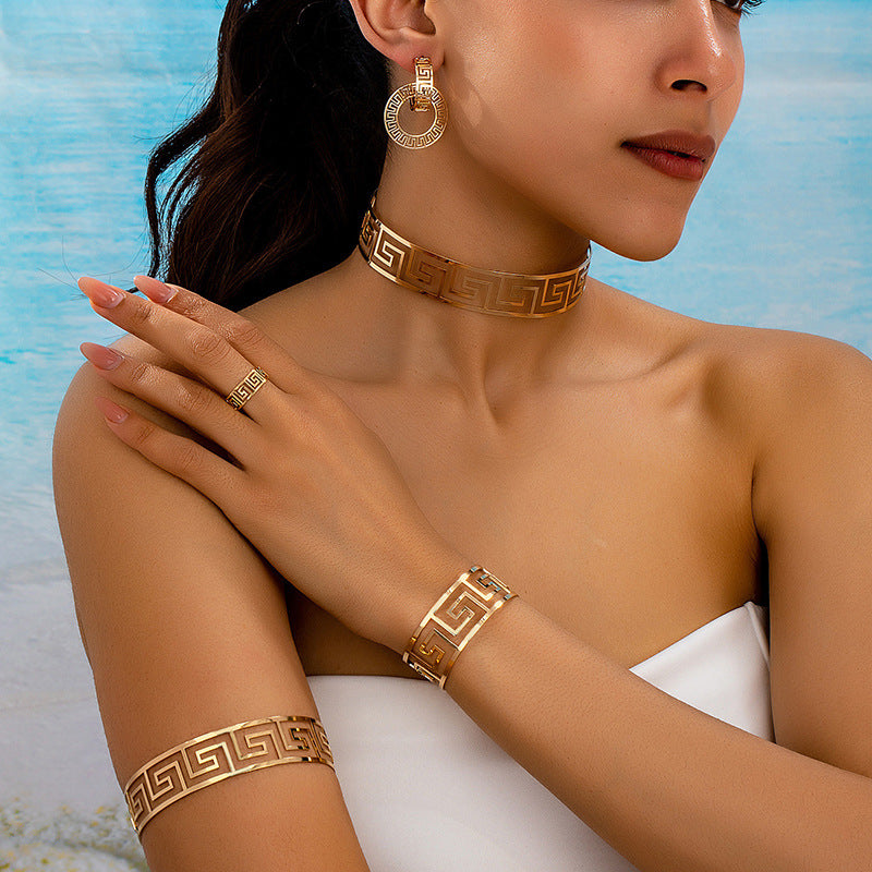 Gold-tone geometric jewelry set on model: choker, matching bracelets, and ring