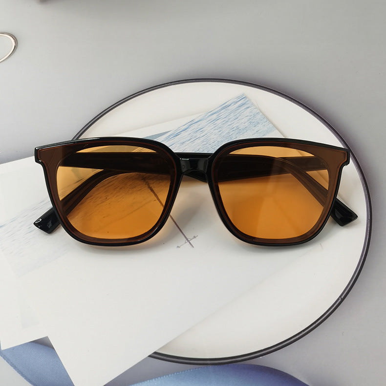 Women's retro small frame sunglasses with black frame and amber-tinted lenses