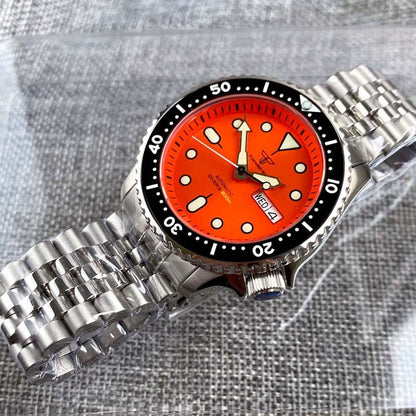 Watch with a red face and silver metal strap on a textured gray background