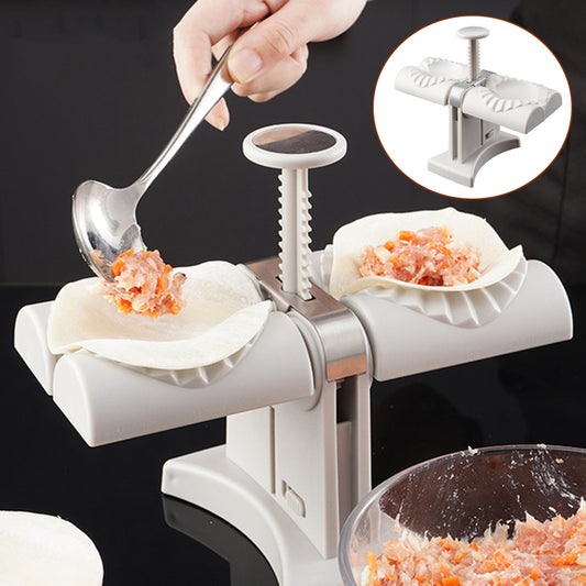 Dumpling maker with two white dumpling skins being filled and shaped, on a black background.