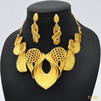 Gold necklace and earrings set on a black mannequin with a light gray background