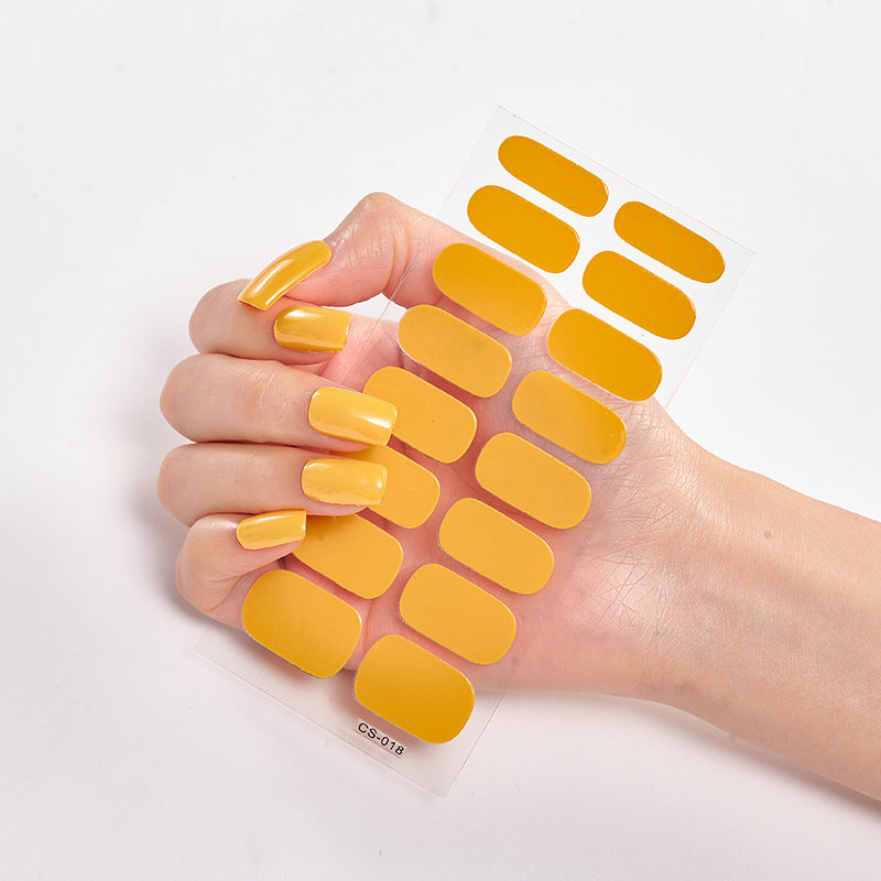 Hand with yellow nail patches on a white background