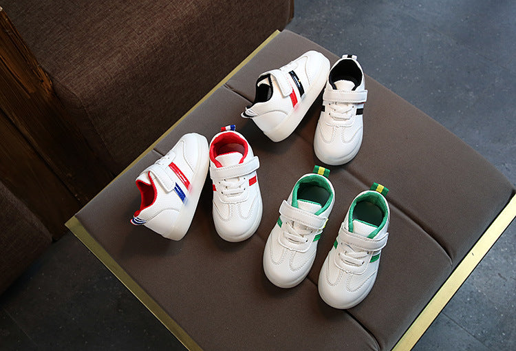 Kids white LED light-up sneakers set with black, red, and green accents on tray