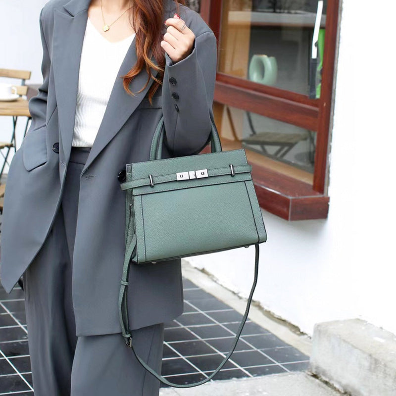 Small square leather shoulder bag with top handle and front clasp, dark green tone