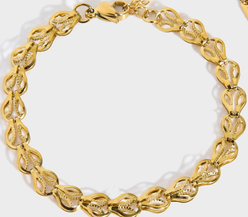 Gold-tone ornament bracelet with raised oval link detailing and lobster-style clasp