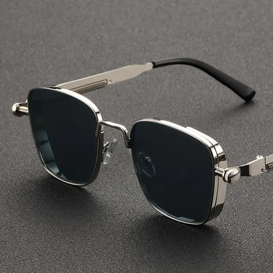 Sunglasses with metallic frame and dark lenses on a gray background