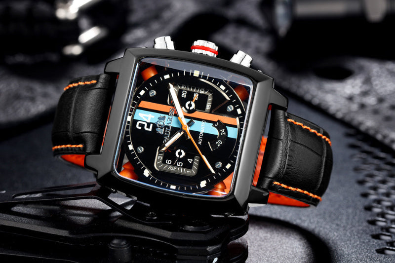 Luxury watch with black and orange strap on a dark textured background