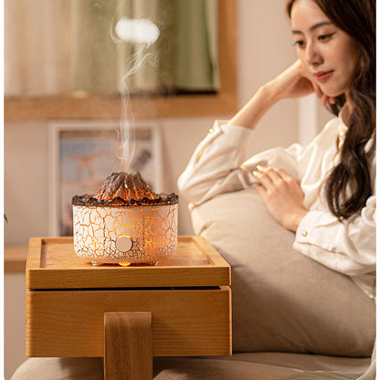Woman sitting on a couch next to a crackled glass diffuser emitting steam.