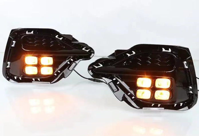 Pair of black LED turn signal fog lamps with amber lights glowing