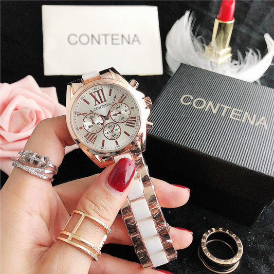 Rose gold watch held by a hand with rings, Contena box in the background