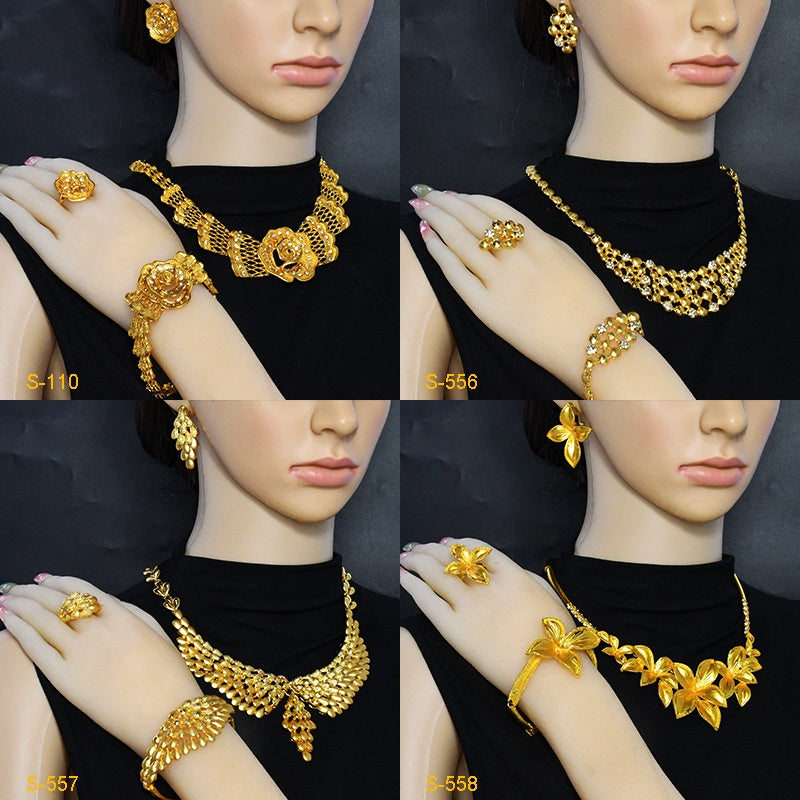 Gold jewelry set on mannequin hands with various pieces including necklaces, rings, and bracelets.