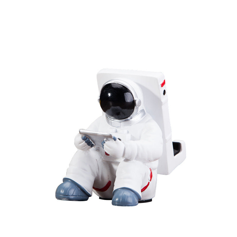 Astronaut mobile phone stand figure holding a phone support, white suit with blue boots