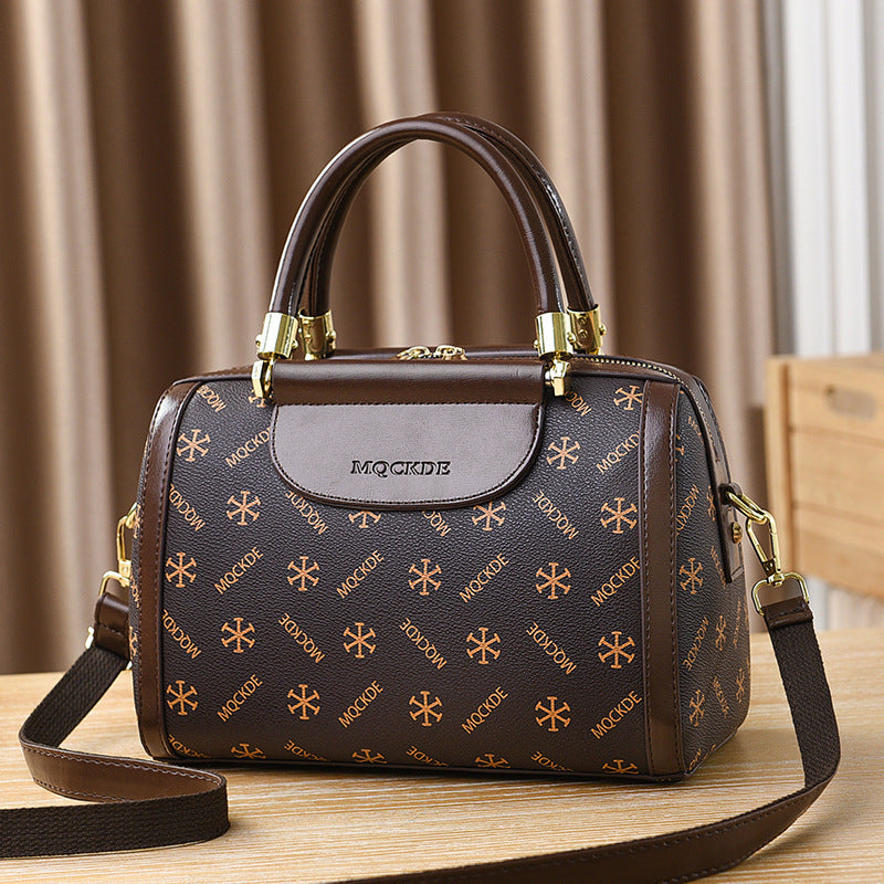 Brown handbag with gold patterns on a wooden surface