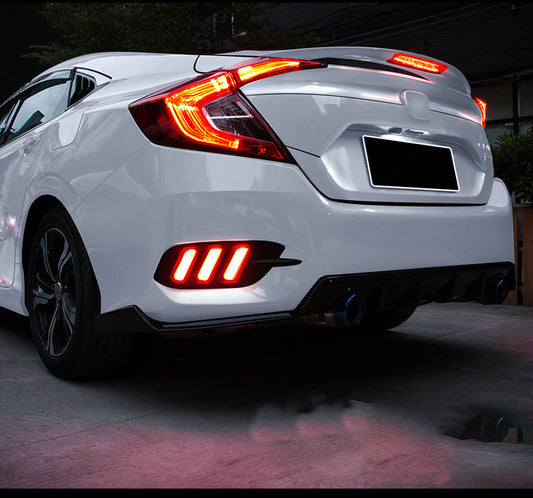 White car with illuminated taillights in a dark setting
