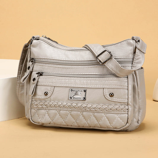 Silver handbag with braided detail on a beige background