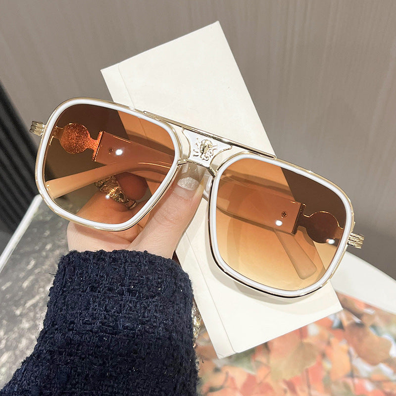 Oversized unisex sunglasses with amber lenses, gold-tone rims and decorative hinge details