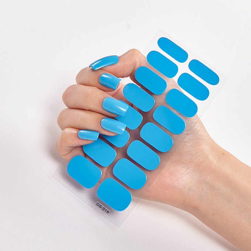 Hand holding blue nail extensions on a white background