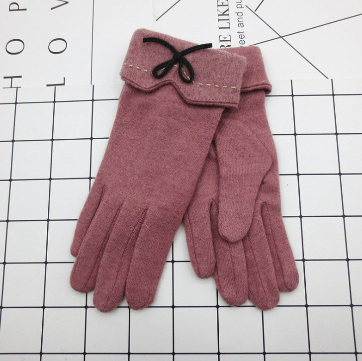 Pair of pink gloves with a bow on a grid background