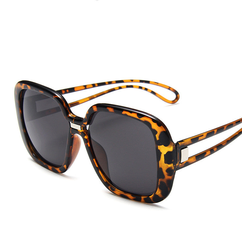 Sunglasses with tortoiseshell frame and dark lenses on a white background