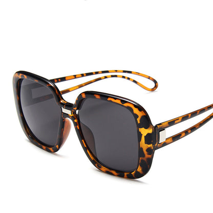 Sunglasses with tortoiseshell frame and dark lenses on a white background