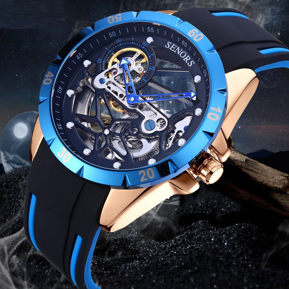 Rose-gold skeleton men's watch with blue bezel and black silicone strap; exposed gears