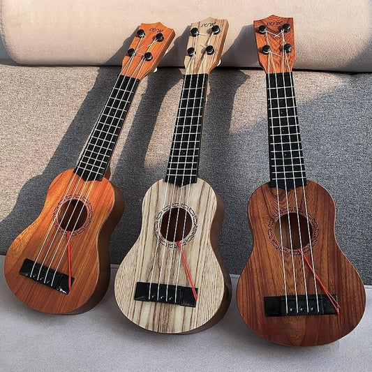 Three small ukuleles with different wood finishes on a gray surface.
