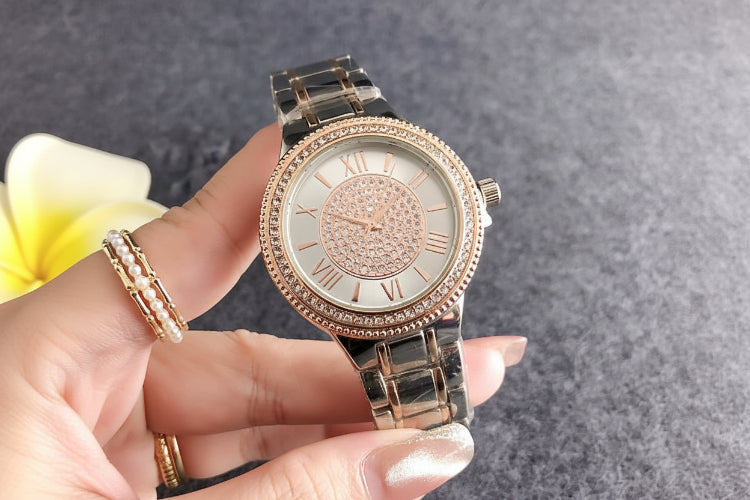 Rose gold bracelet watch with crystal bezel, light dial, and dark metal link band