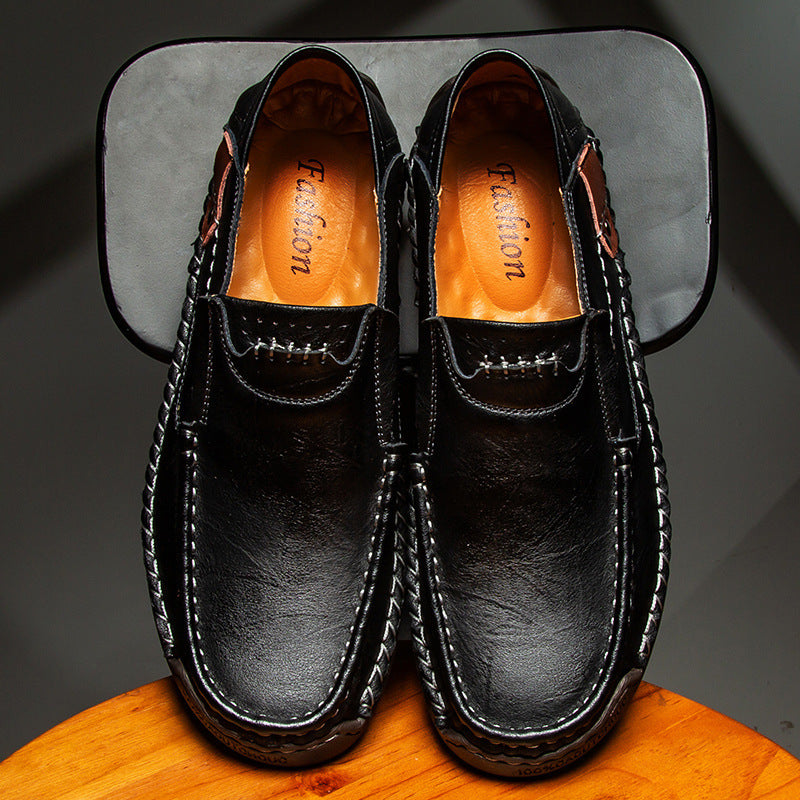 Black leather slip-on loafer pair with orange-lined interior and stitched trim
