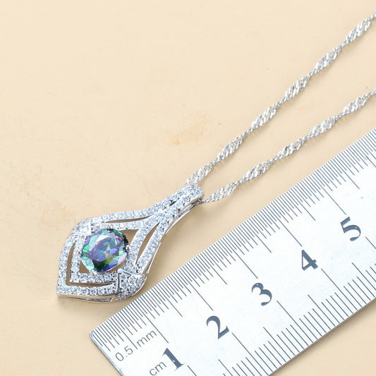 Silver necklace with a colorful pendant on a ruler for scale