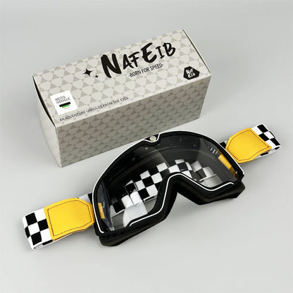 Motorcycle goggles with checkered strap and yellow accents next to a branded box on a gray background