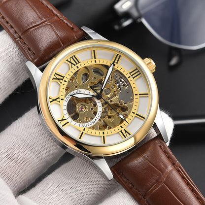 Luxury watch with gold face and brown leather strap on a gray surface