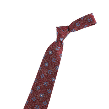 Red patterned tie with a gold violin-shaped accessory on a white background