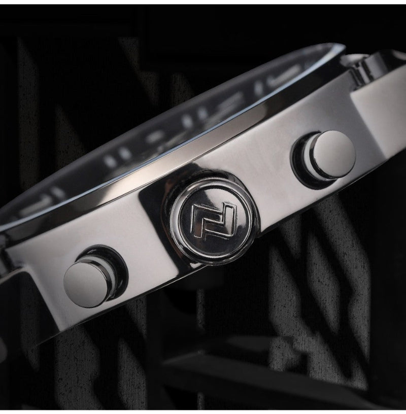 Close-up of a silver watch with a brand logo on a dark background