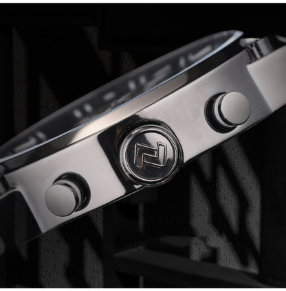 Close-up of a silver watch with a brand logo on a dark background