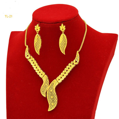 Gold necklace and earrings set on a red velvet stand