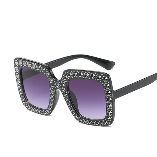 Sunglasses with decorative frame and purple lenses on a white background