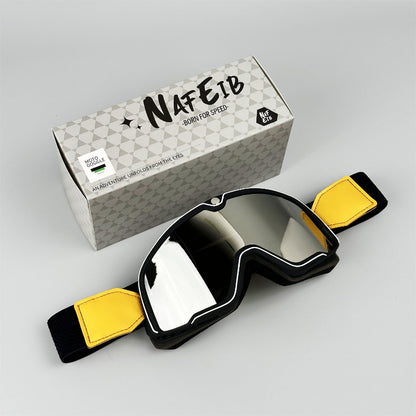 Black goggles with yellow straps and a branded box on a gray background