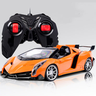 Orange toy car with black remote control on a white background