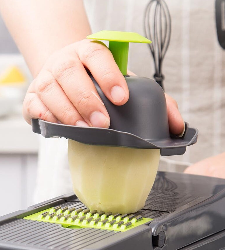 Person using a green and black vegetable peeler on a kitchen counter.