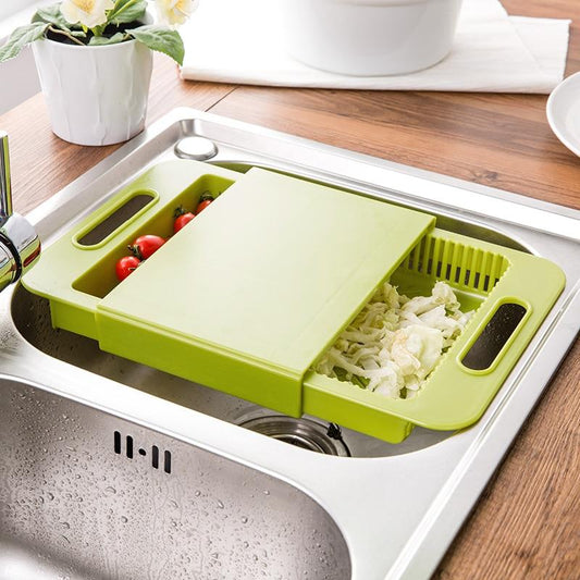 Green kitchen cutting board with built-in sink compartment on a wooden countertop.