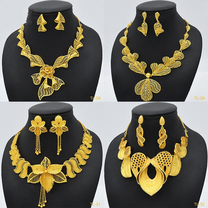 Gold jewelry set with necklace and earrings on black mannequin busts against a white background.