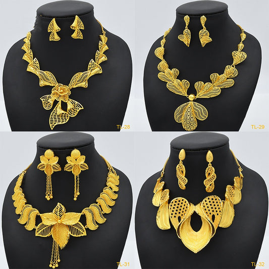 Gold jewelry set with necklace and earrings on black mannequin busts against a white background.